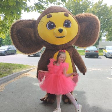 Ребенок обнимает ростовую куклу чебурашка