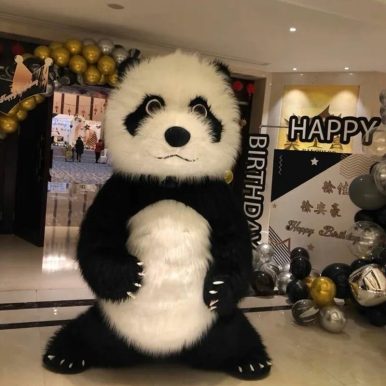 Ребенок обнимает ростовую куклу мишка панда